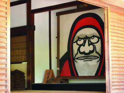 Daruma-zu (a painting of Bodhidharma) that greets worshippers at the reception desk of each hall. The motif is Daruma Daishi, the founder of the Zen sect.