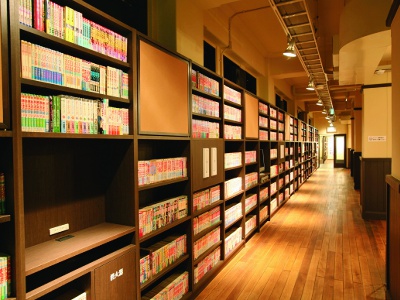200mの本棚「マンガの壁」には、1970年代～現代の漫画5万冊が並ぶ。
