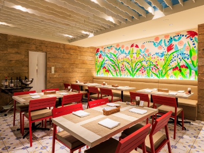 The interior of the restaurant, decorated with murals created by Ellie Omiya, is reminiscent of the Mediterranean Sea.