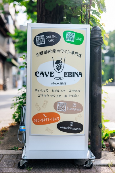 京都御苑南東角、丸太町通に面した店舗。観光の帰りにも立ち寄りやすい。オンラインショップやLINEのQRコードがある看板が目印。