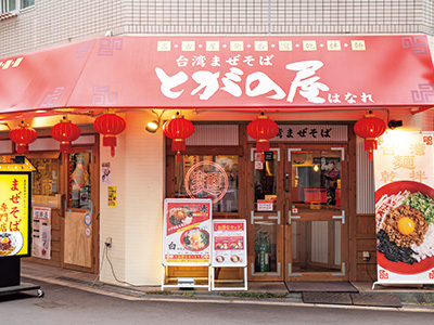 赤い看板が目印のこじんまりした店舗。夜は台湾屋台風の居酒屋に早変わり。