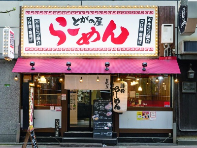 徒歩3分の場所にある本店「らーめん とがの屋」は、今秋に創業10年を迎える人気店。本店でこのページを撮影して見せると、唐揚げ（2個入り）1皿サービス！（ 2023年12月31日まで ）