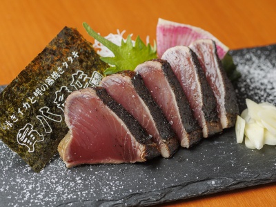 Straw-roasted bonito tataki 2,200 yen (5 pieces). When the fatty season is good, try it with salt tataki. It is always served with fresh slices of garlic, wasabi (Japanese horseradish) and other condiments.