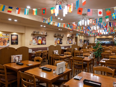 世界各国の国旗が飾られたにぎやかで広々とした店内。事前予約で団体の個室利用も可能。