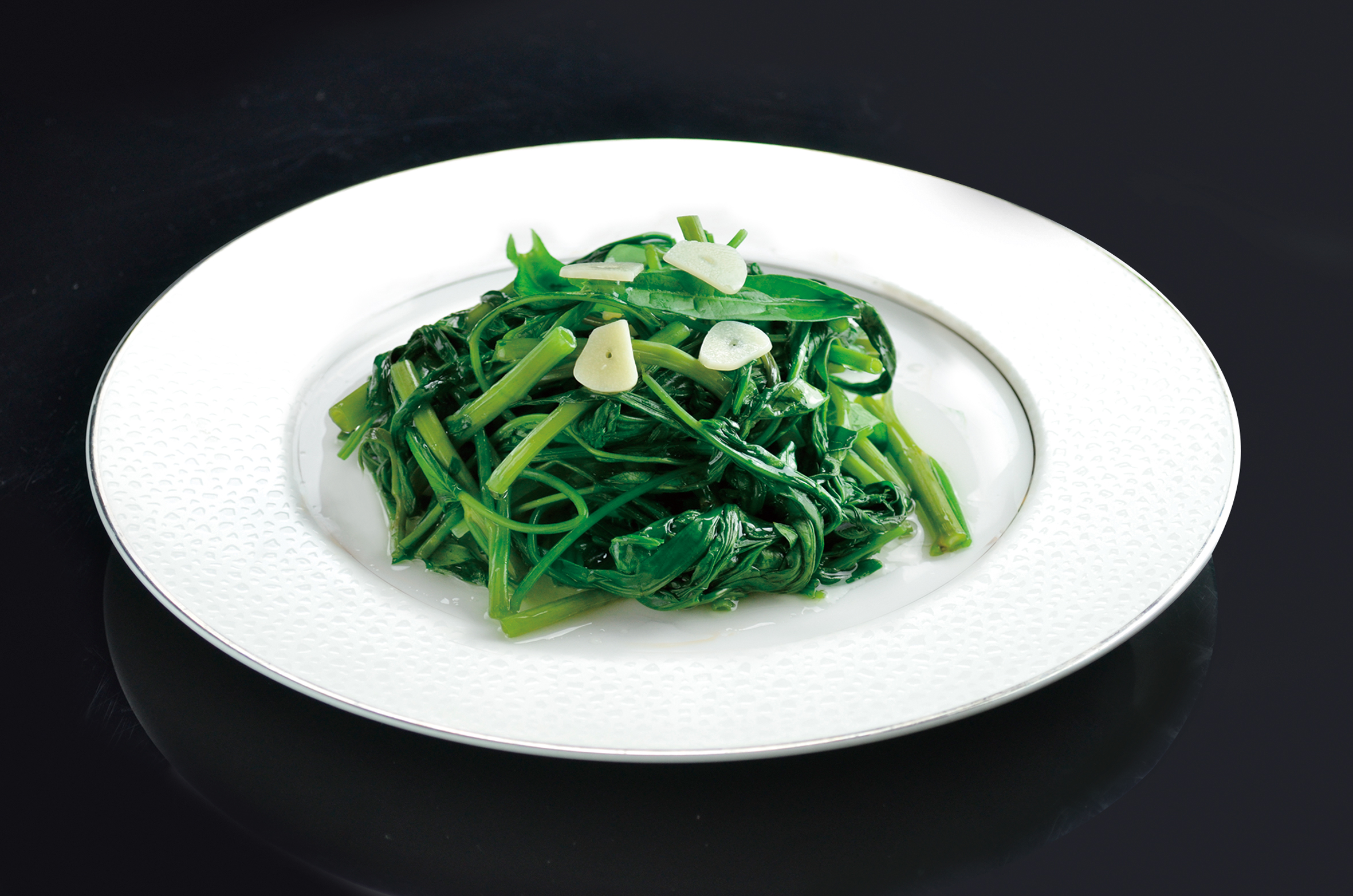 空心菜の炒め1,900円は、シャキッと歯ざわりの良い空心菜を強火で一気に炒めた一皿。シンプルながらも職人の火入れの妙が光る。