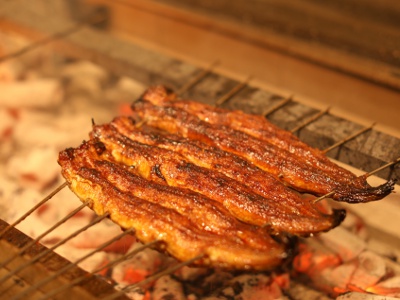 秘伝のたれにくぐらせて香ばしく仕上げる「焼き」の工程。絶妙な焼き加減に職人の技が光る。